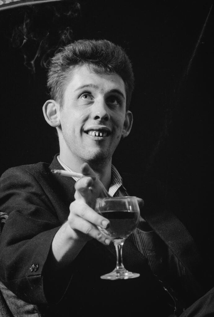 Shane with Glass and Cigarette. The Pogues, Liverpool. Photo by Andrew Catlin.